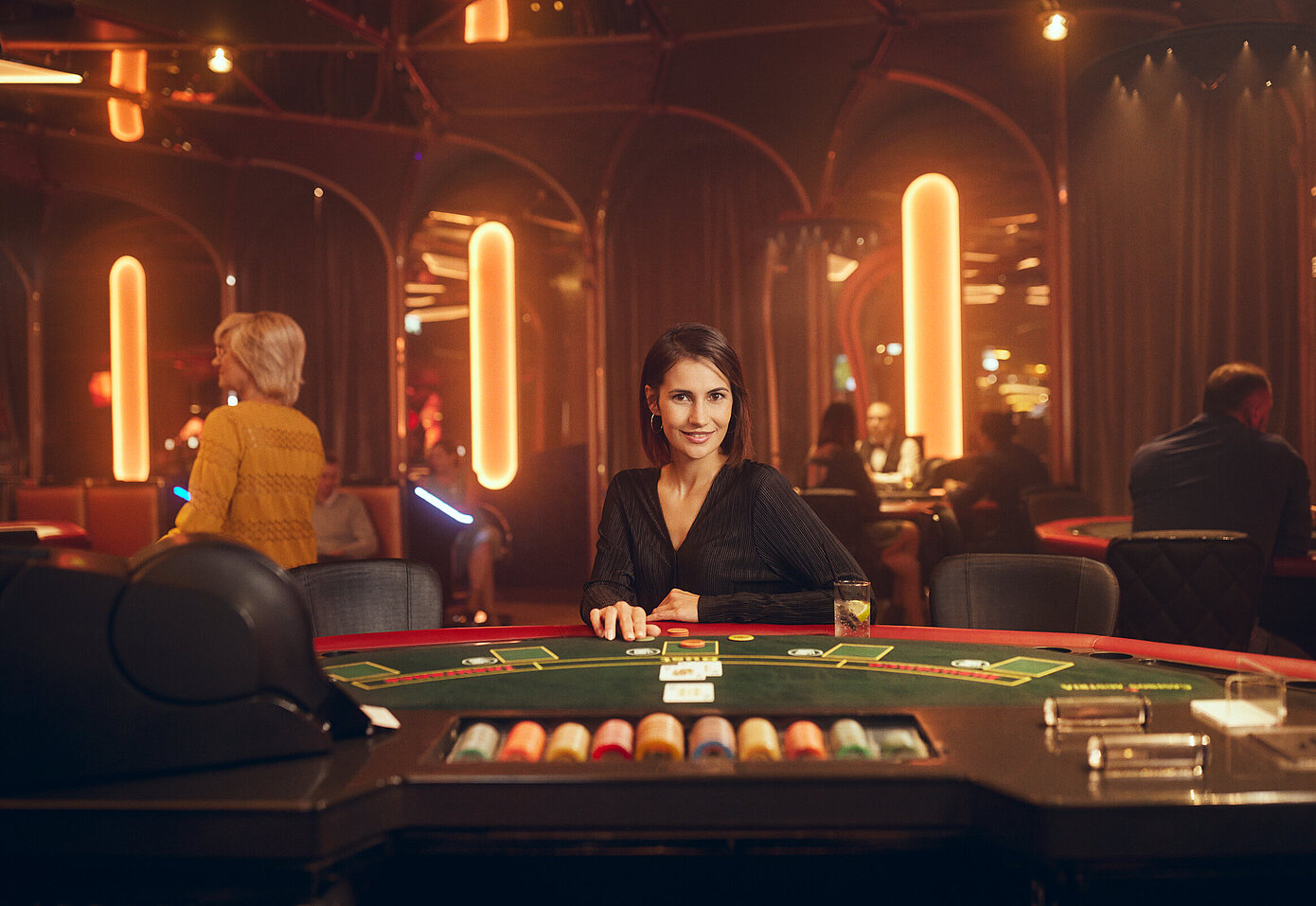 Dunkelhaarige Dame sitzt am Black Jack Tisch im Casino