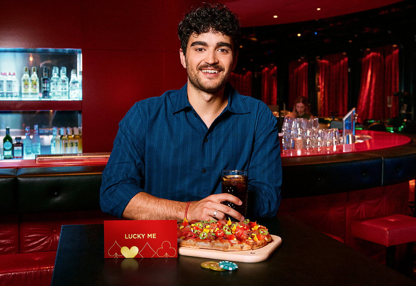 Mann an der Casino Bar mit Lucky Me Gutschein, Pinsa und Cola