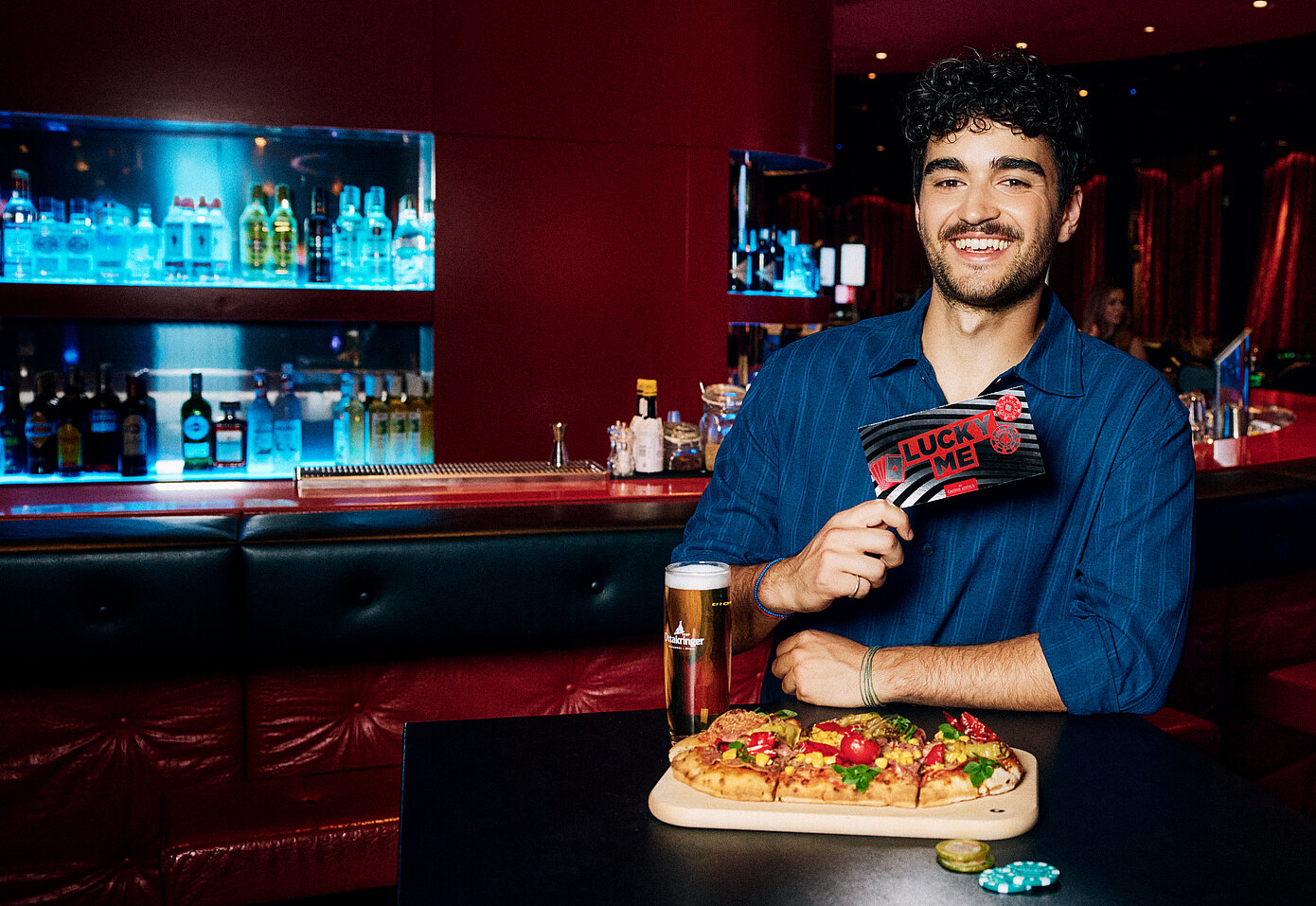 Mann an der Casino Bar mit Lucky Me Gutschein, Pinsa und Cola