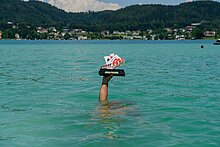Poker EM 2025 Sujet Hand mit Pokal im Wörthersee