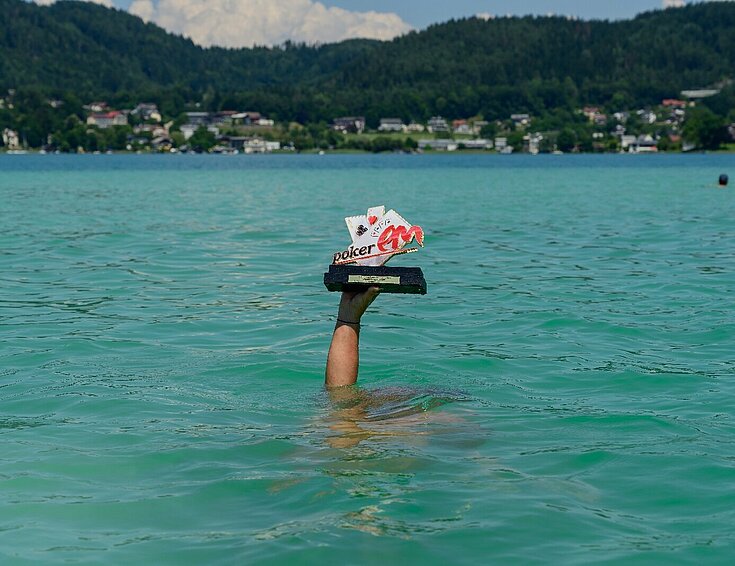 Casinos Austria AG Poker EM 2025 Sujet Hand mit Pokal im Wörthersee