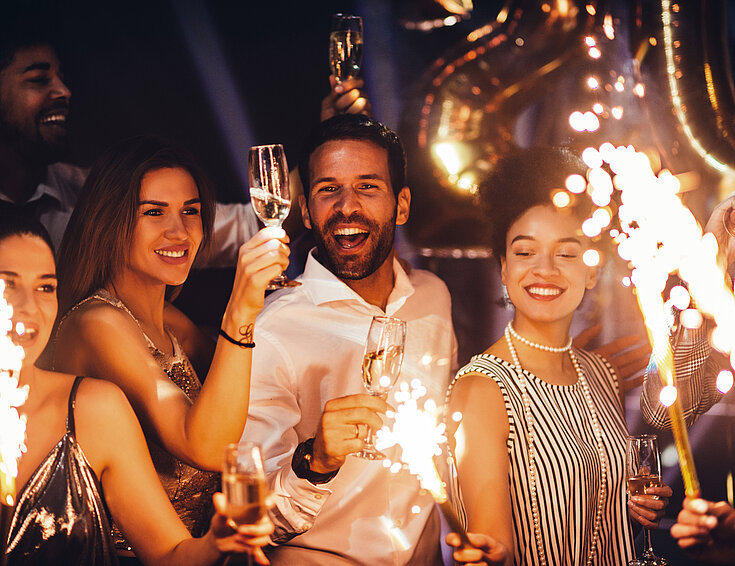 Shutterstock Gruppe von Menschen feiern Silvester mit Sekt und Wunderkerzen