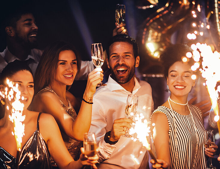 Shutterstock Gruppe von Menschen feiern Silvester mit Sekt und Wunderkerzen