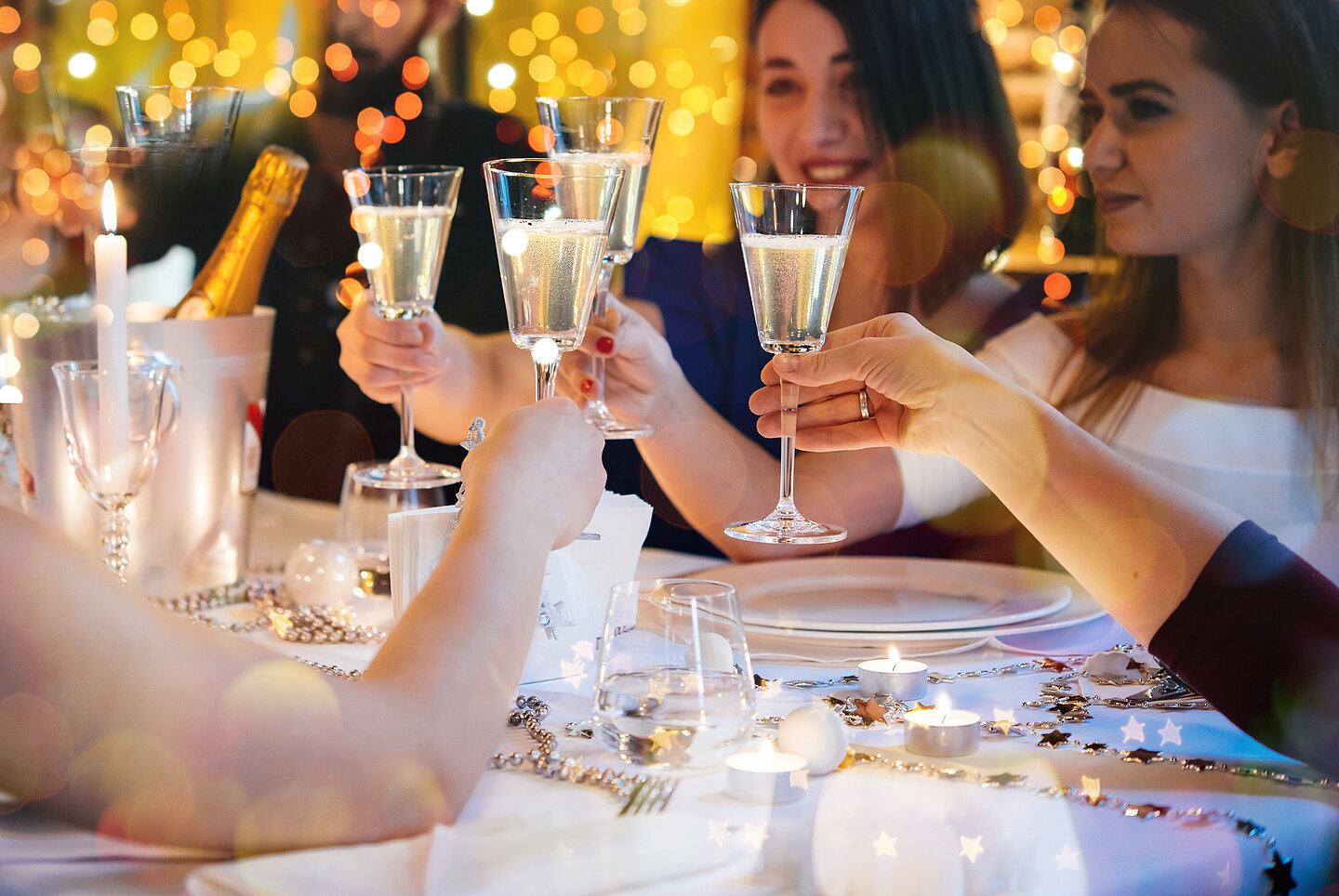 Gruppe feiernde Menschen stossen mit Glas Sekt an