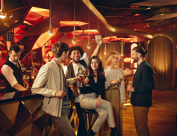 Casinos Austria Gäste sitzen mit Getränk an der Casino Bar