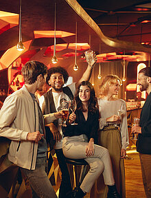 Gäste sitzen mit Getränk an der Casino Bar
