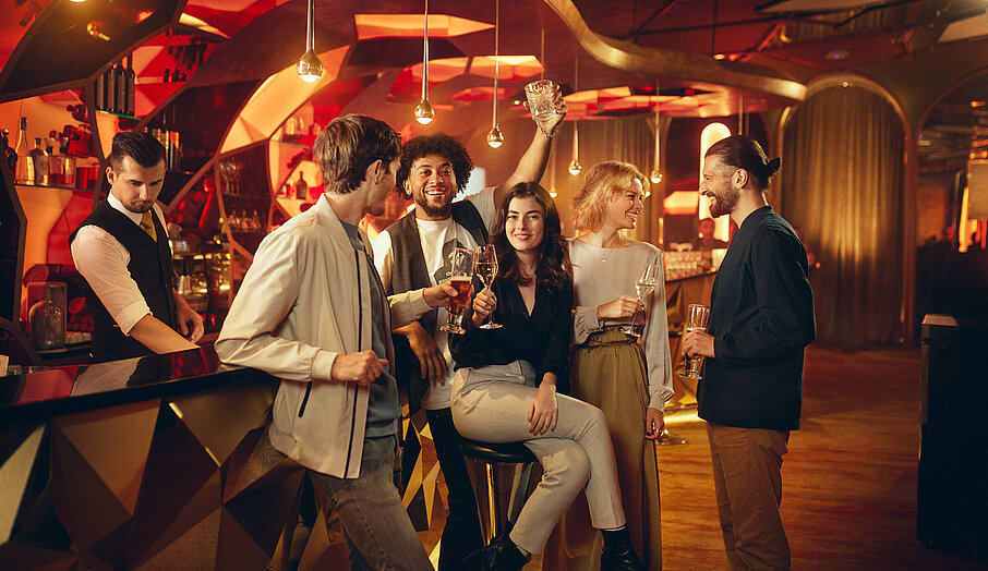 Gäste sitzen mit Getränk an der Casino Bar