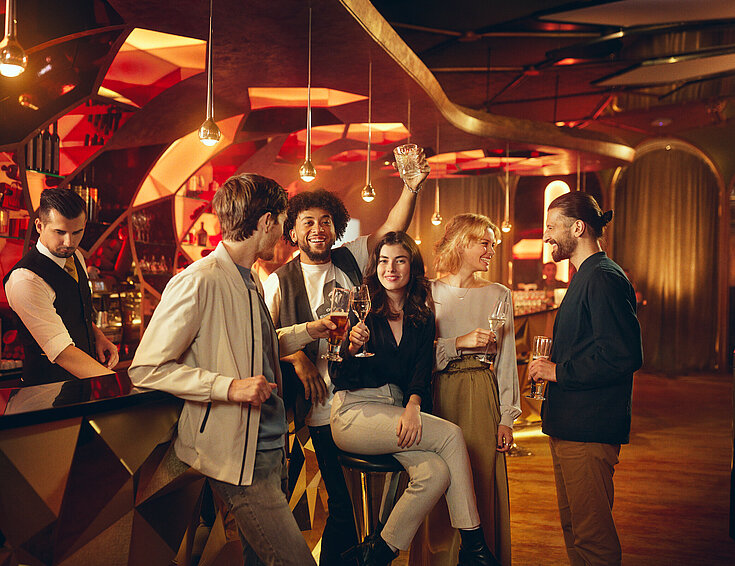 Casinos Austria Gäste sitzen mit Getränk an der Casino Bar