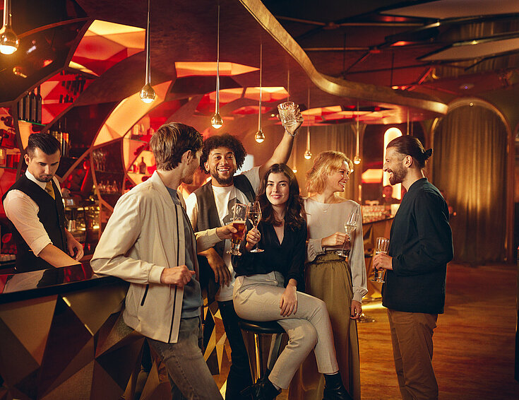 Casinos Austria Gäste sitzen mit Getränk an der Casino Bar