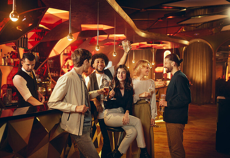 Gäste sitzen mit Getränk an der Casino Bar