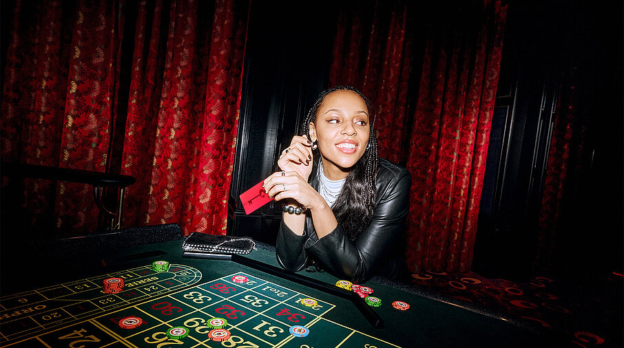 Frau sitzt am Roulette Tisch mit RED Member Card
