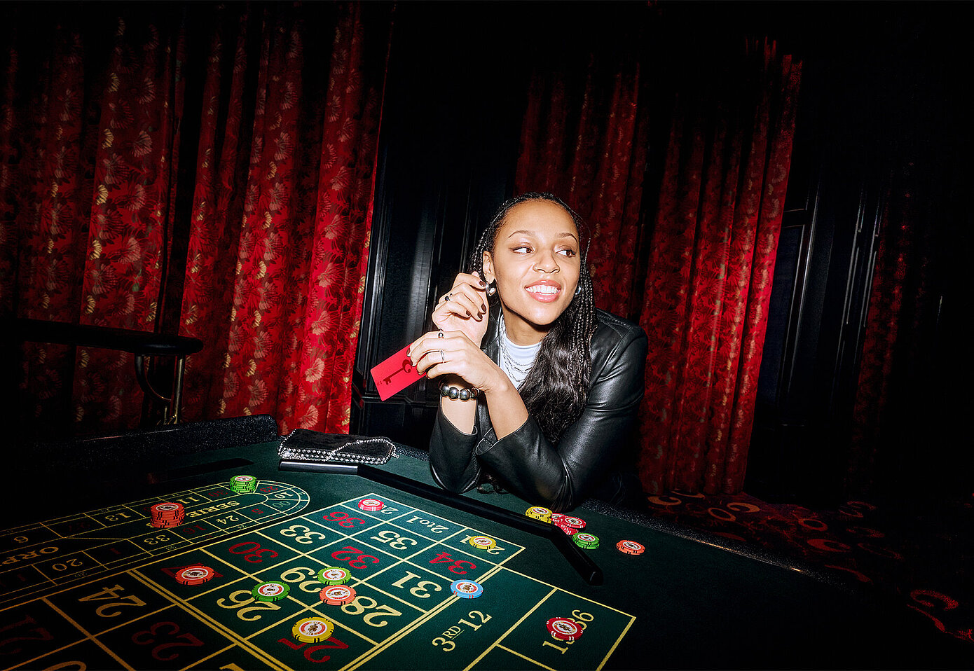 Frau sitzt am Roulette Tisch mit RED Member Card