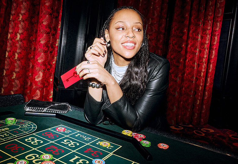 Frau sitzt am Roulette Tisch mit RED Member Card