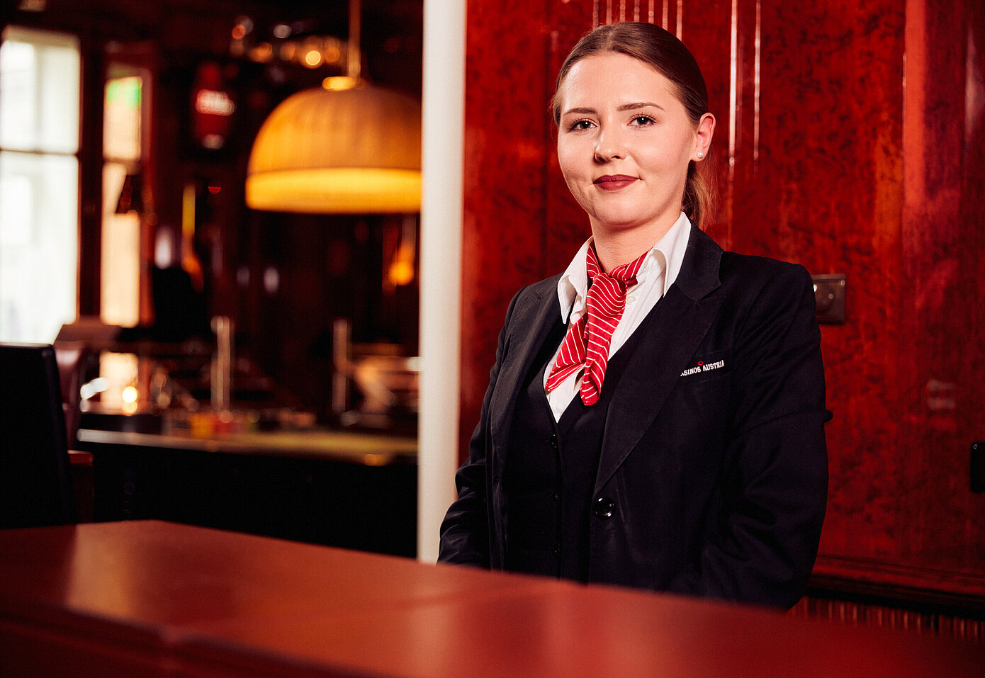 Casino Assistentin in Casino Kleidung hinter der Rezeption
