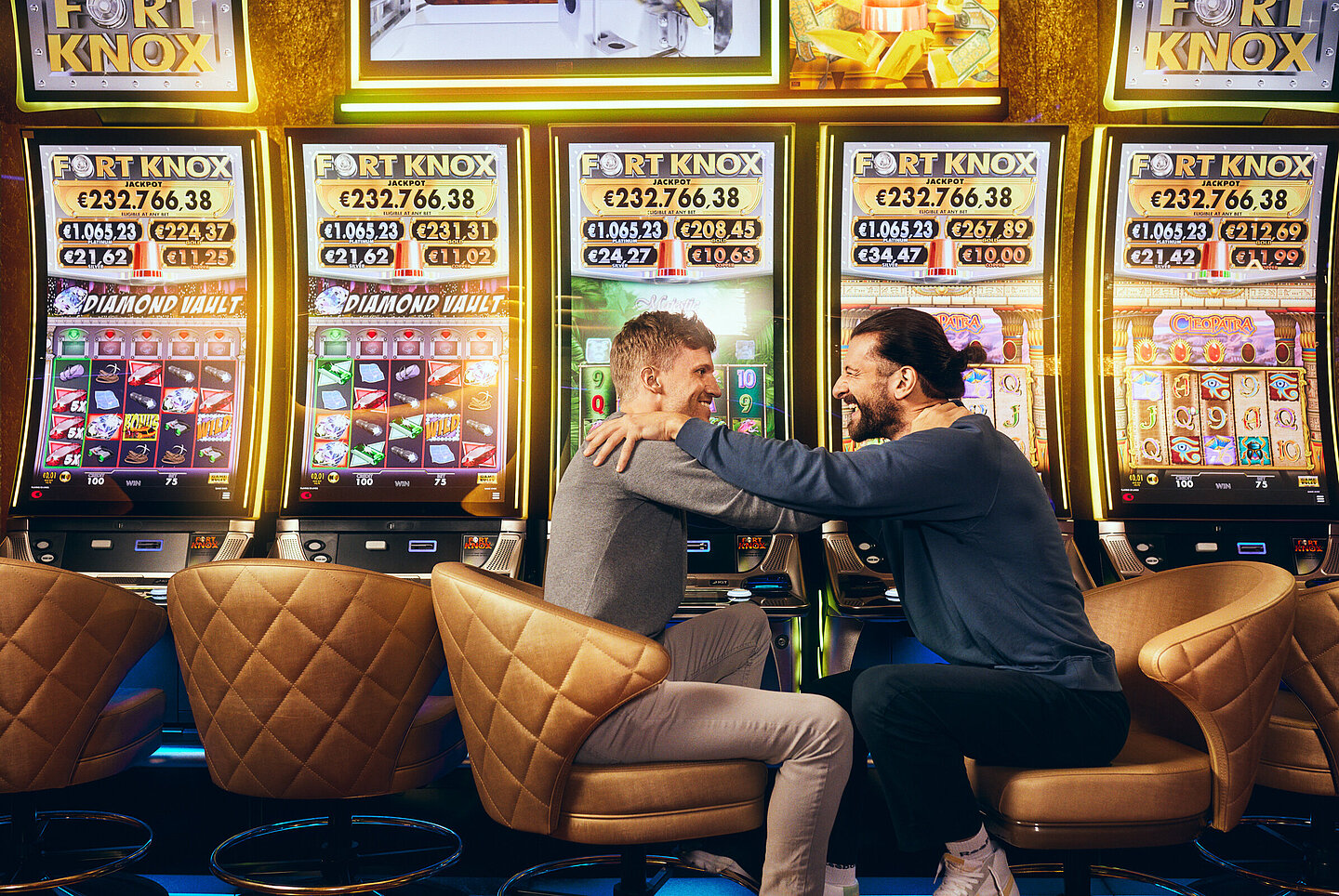 Zwei Männer sitzen vor den Fort Knox Spielautomaten von Casinos Austria