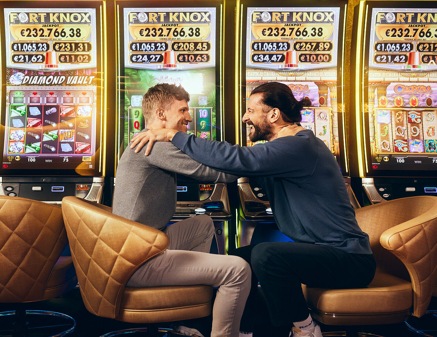 Zwei Männer sitzen vor den Fort Knox Spielautomaten von Casinos Austria