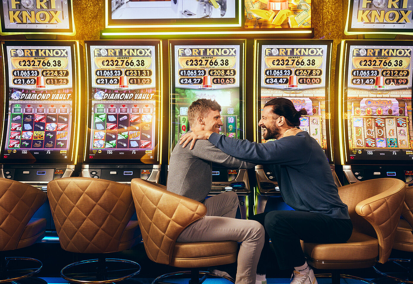 Zwei Männer sitzen vor den Fort Knox Spielautomaten von Casinos Austria