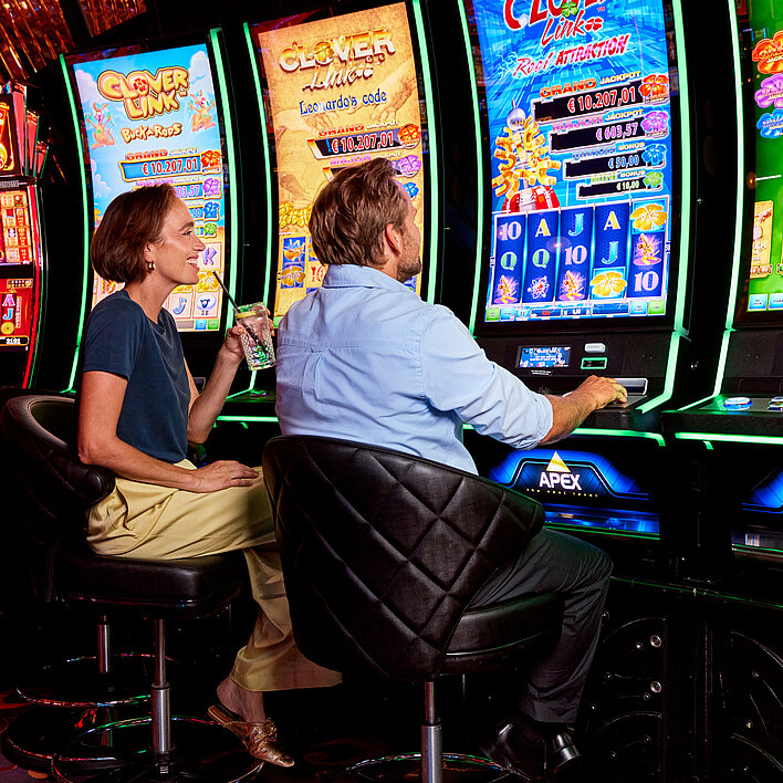 Frau und Mann vor Spielautomaten