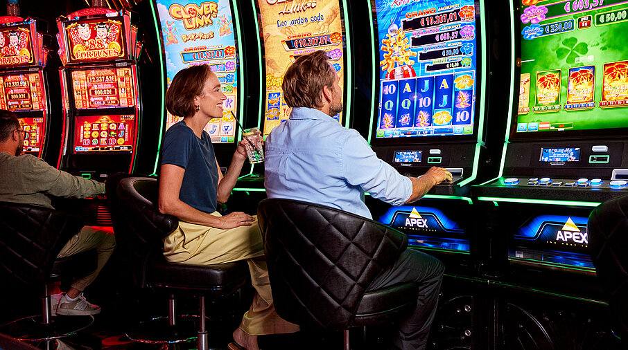 Frau und Mann vor Spielautomaten
