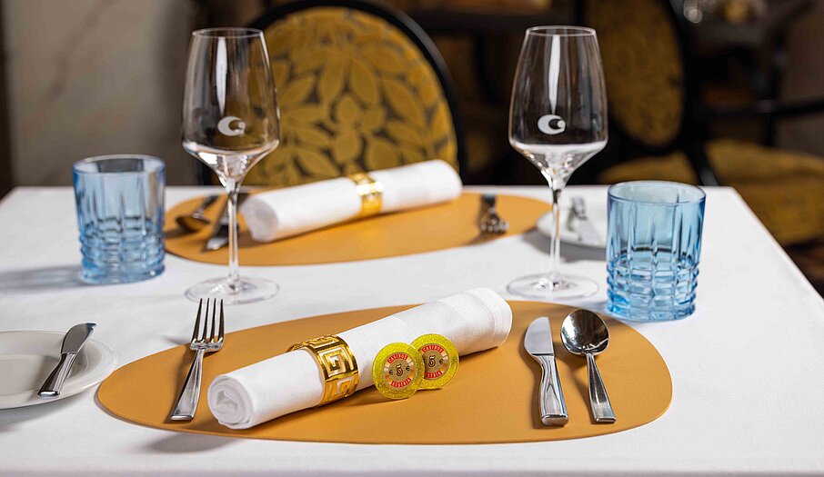 Gedeckter Tisch für Genuss & Casino im Restaurant mit 2 Jetons zu 5 Euro