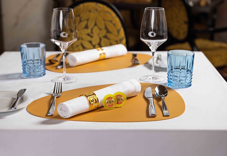 Gedeckter Tisch für Genuss & Casino im Restaurant mit 2 Jetons zu 5 Euro