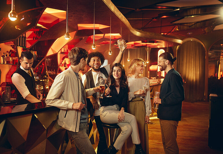 Gäste sitzen mit Getränk an der Casino Bar