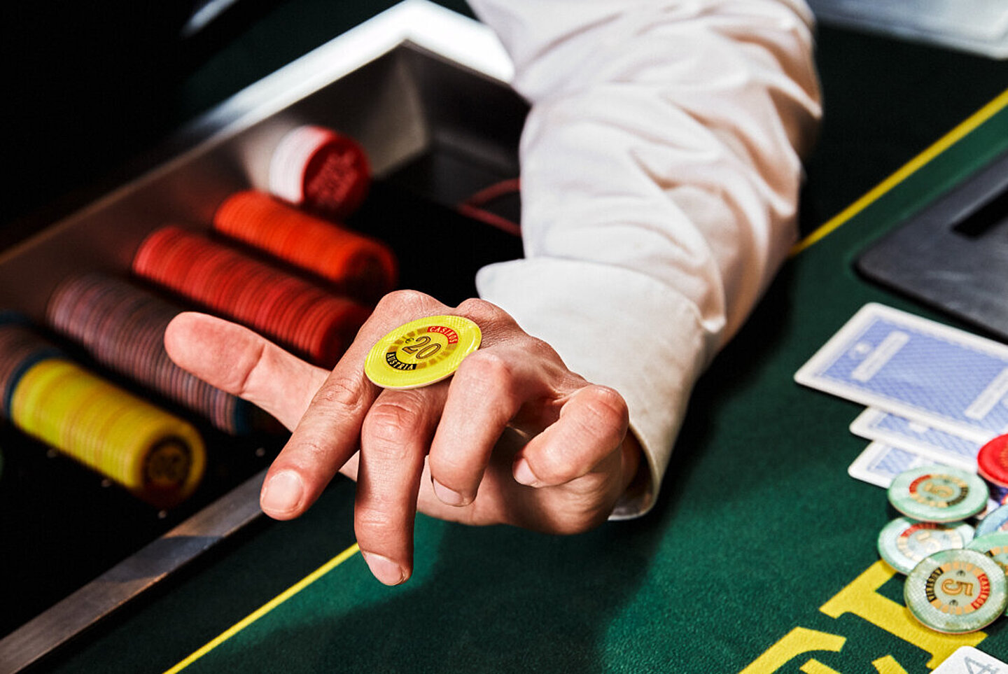 Poker Table Karten Dealer lässt Jeton über Hand wandern