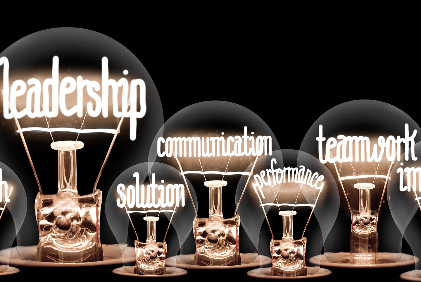 Glühbirnen mit leadership, communication, teamwork Leuchtschrift