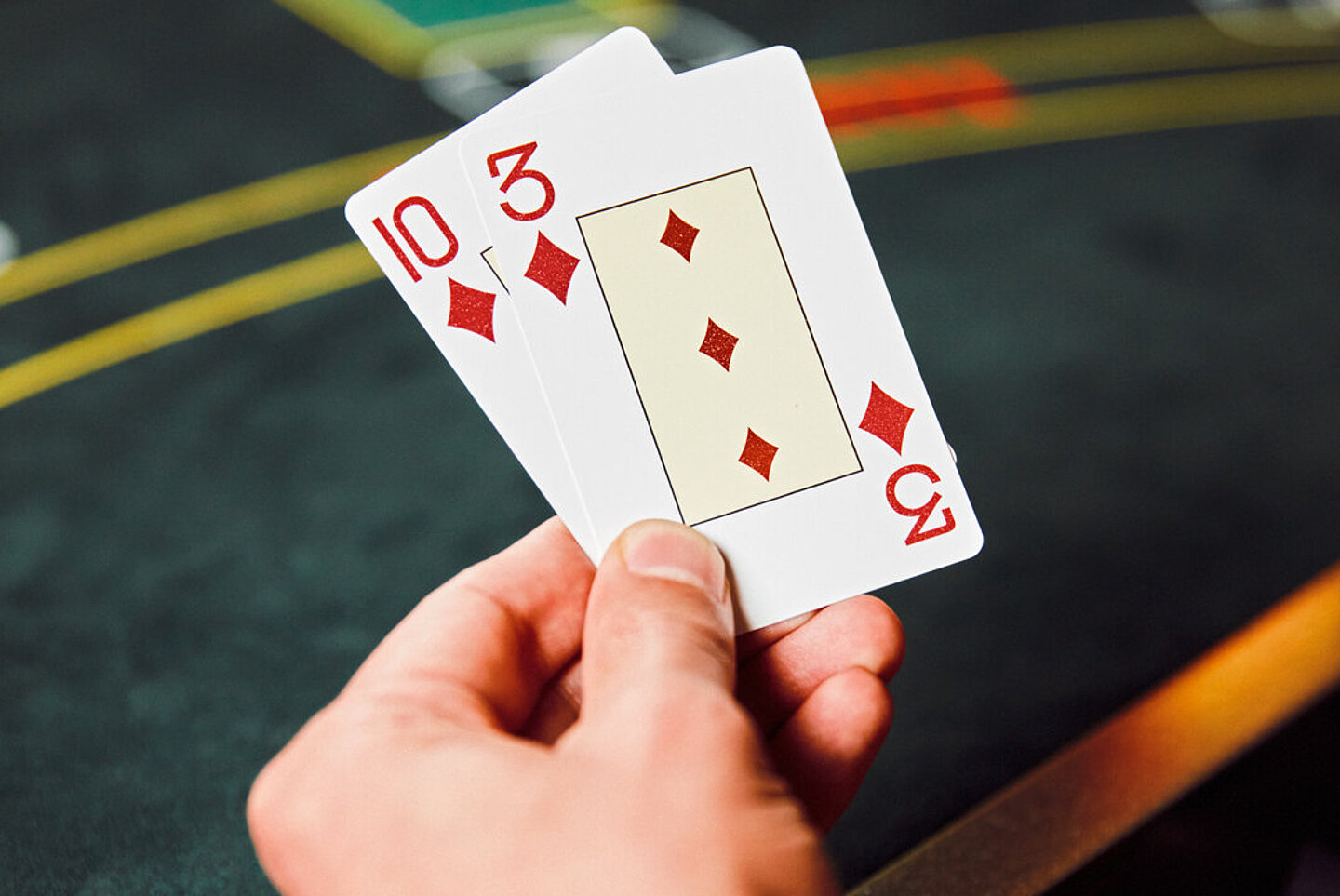 Croupier-Hand hält Black Karten 10 und 3 in der Hand