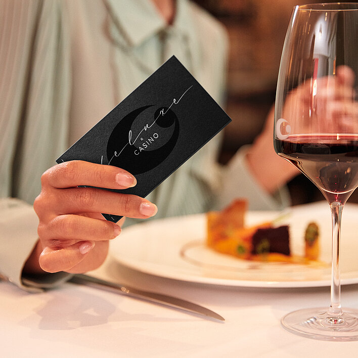 Gast mit Dinner Deluxe Gutschein bei gedecktem Tisch