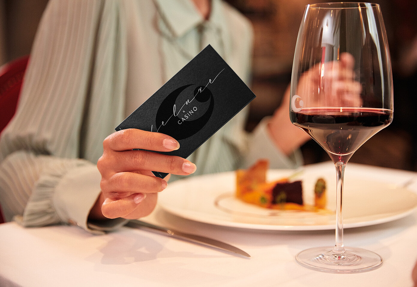 Gast mit Dinner Deluxe Gutschein bei gedecktem Tisch