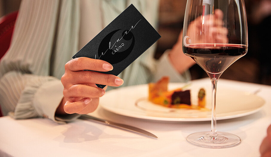 Gast mit Dinner Deluxe Gutschein bei gedecktem Tisch