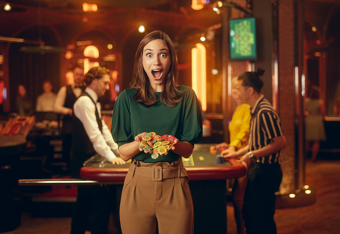 Dame im Casino mit großen Augen und weit geöffnetem Mund hält Jetons in Händen