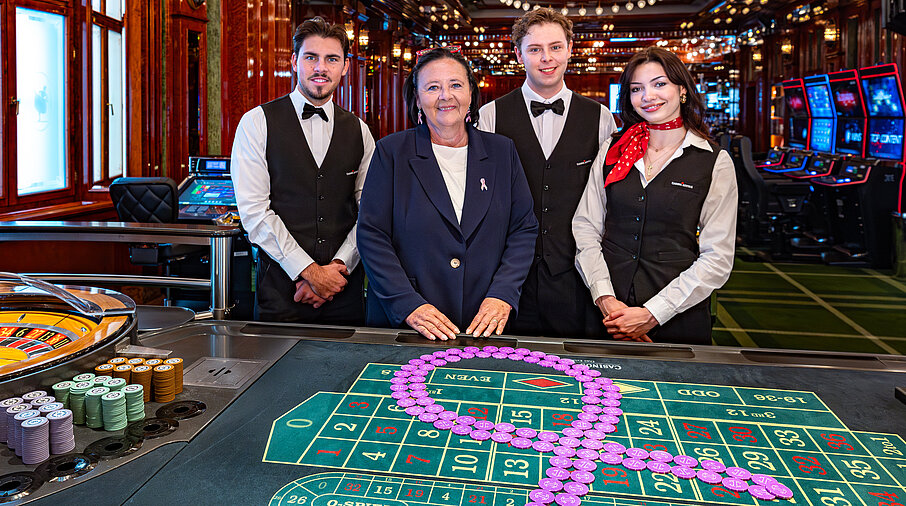 Pink Casino Night - Doris Kiefhaber Geschäftsführerin der Österr. Krebshilfe und der Aktion Pink Ribbon mit Croupière und Croupiers am Roulette-Tisch mit Pink Ribbon Symbol