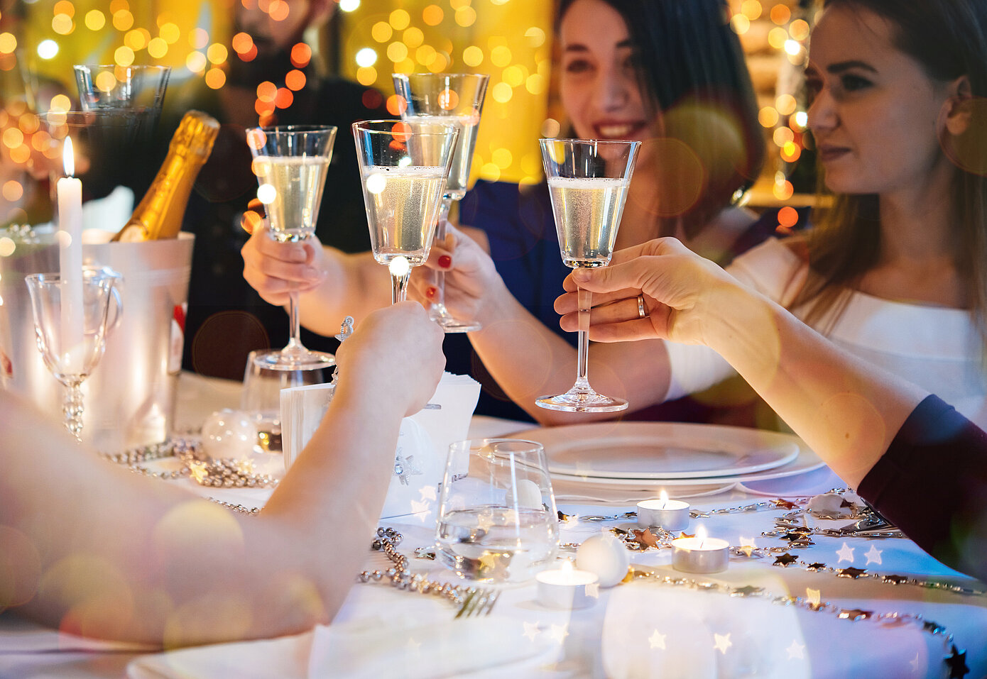 Freunde beim Feiern stoßen mit Champagner-Gläsern an