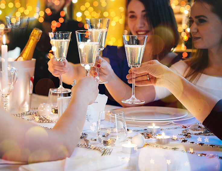 Freunde beim Feiern stoßen mit Champagner-Gläsern an