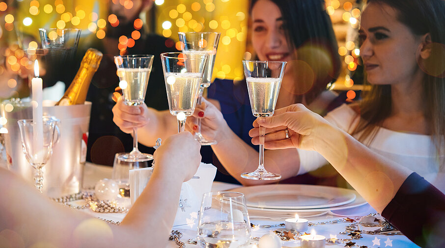 Freunde beim Feiern stoßen mit Champagner-Gläsern an