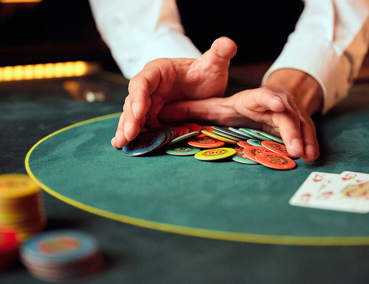 Casinos Austria Poker Close-up Dealer schiebt Jetons Pot Gewinn Cashgame