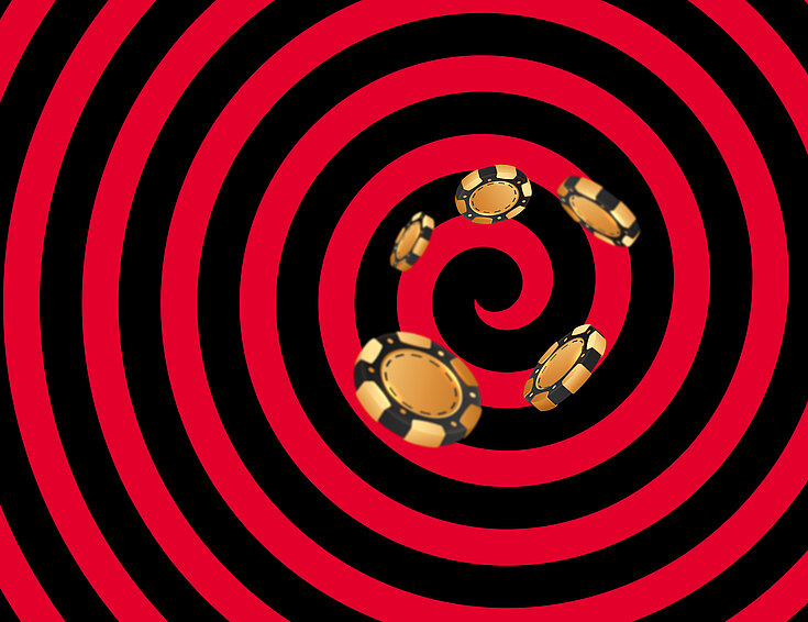 Gold-schwarze Casino Jetons auf schwarz-rotem Hintergrund