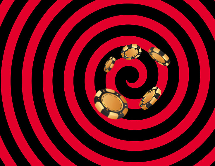 Gold-schwarze Casino Jetons auf schwarz-rotem Hintergrund