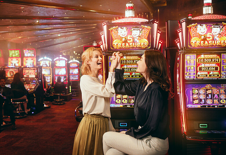 Zwei junge Damen jubeln im Automatensaal von Casinos Austria