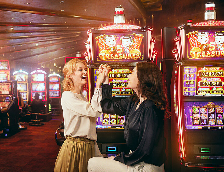 Zwei junge Damen jubeln im Automatensaal von Casinos Austria