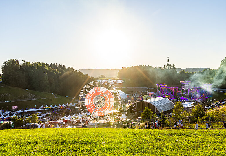 Electric Love Festival Gelände mit Sonnenblumenfeld im Vordergrund