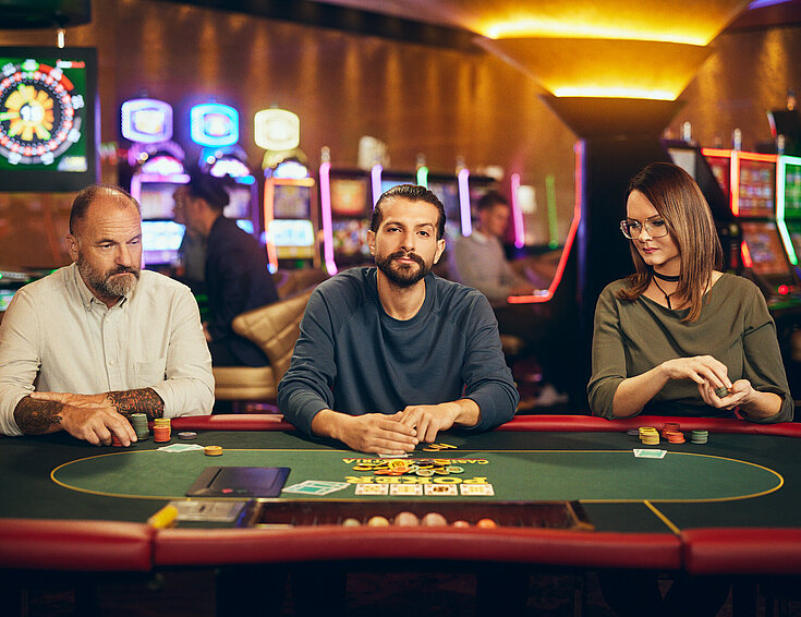 Casinos Austria Dame und zwei Herren spielen Poker bei Casinos Austria