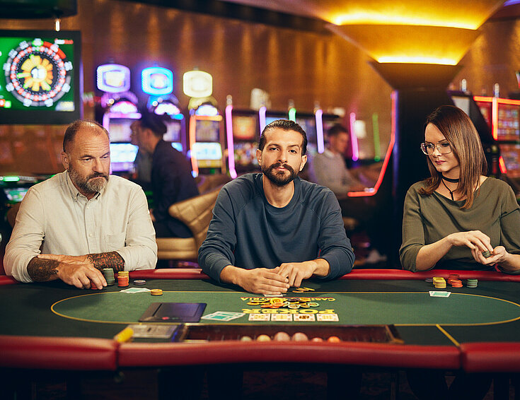 Casinos Austria Dame und zwei Herren spielen Poker bei Casinos Austria