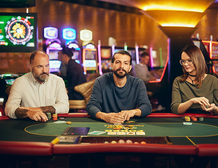 Casinos Austria Dame und zwei Herren spielen Poker bei Casinos Austria