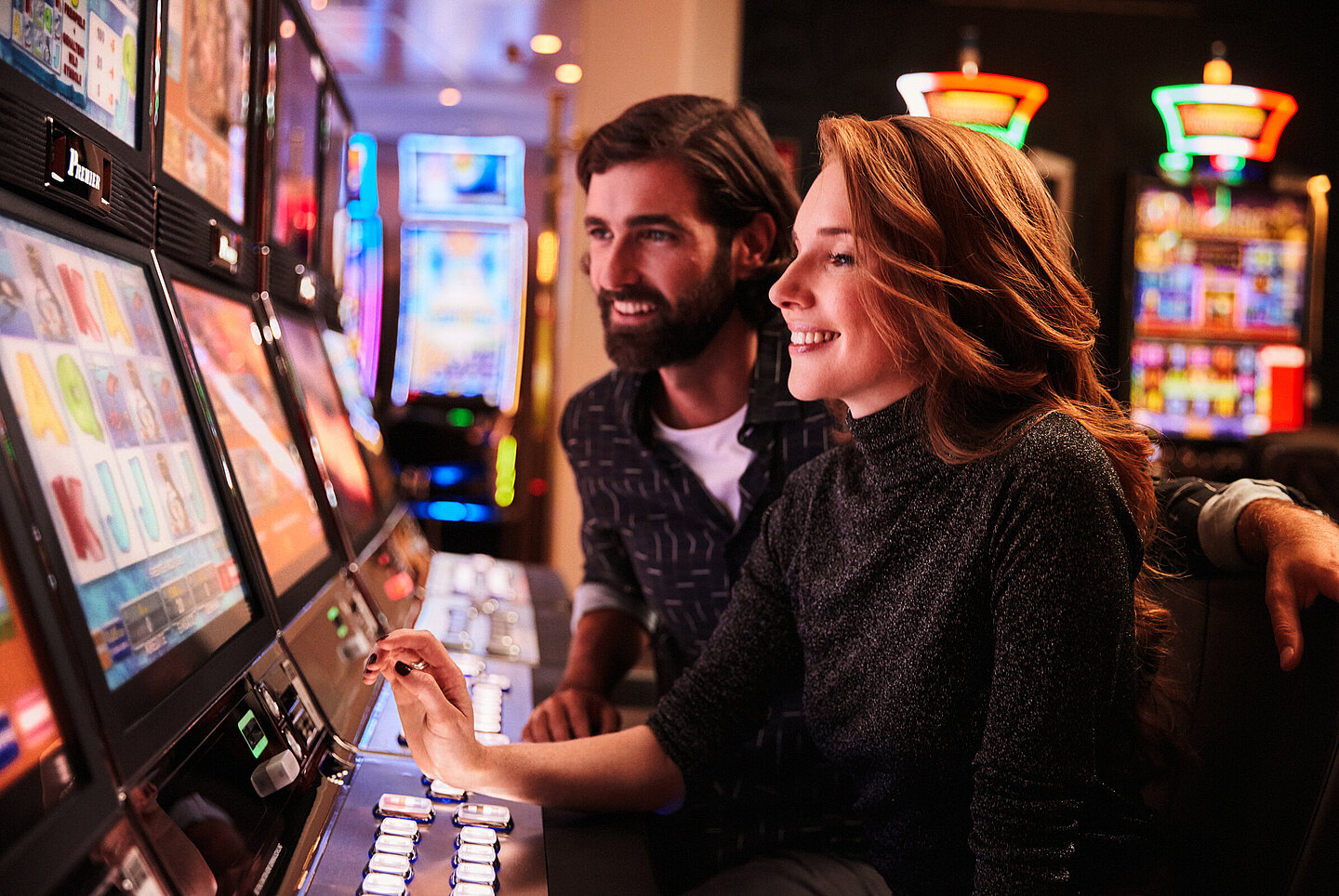 Frau und Mann spielen an den Spielautomaten im Casino