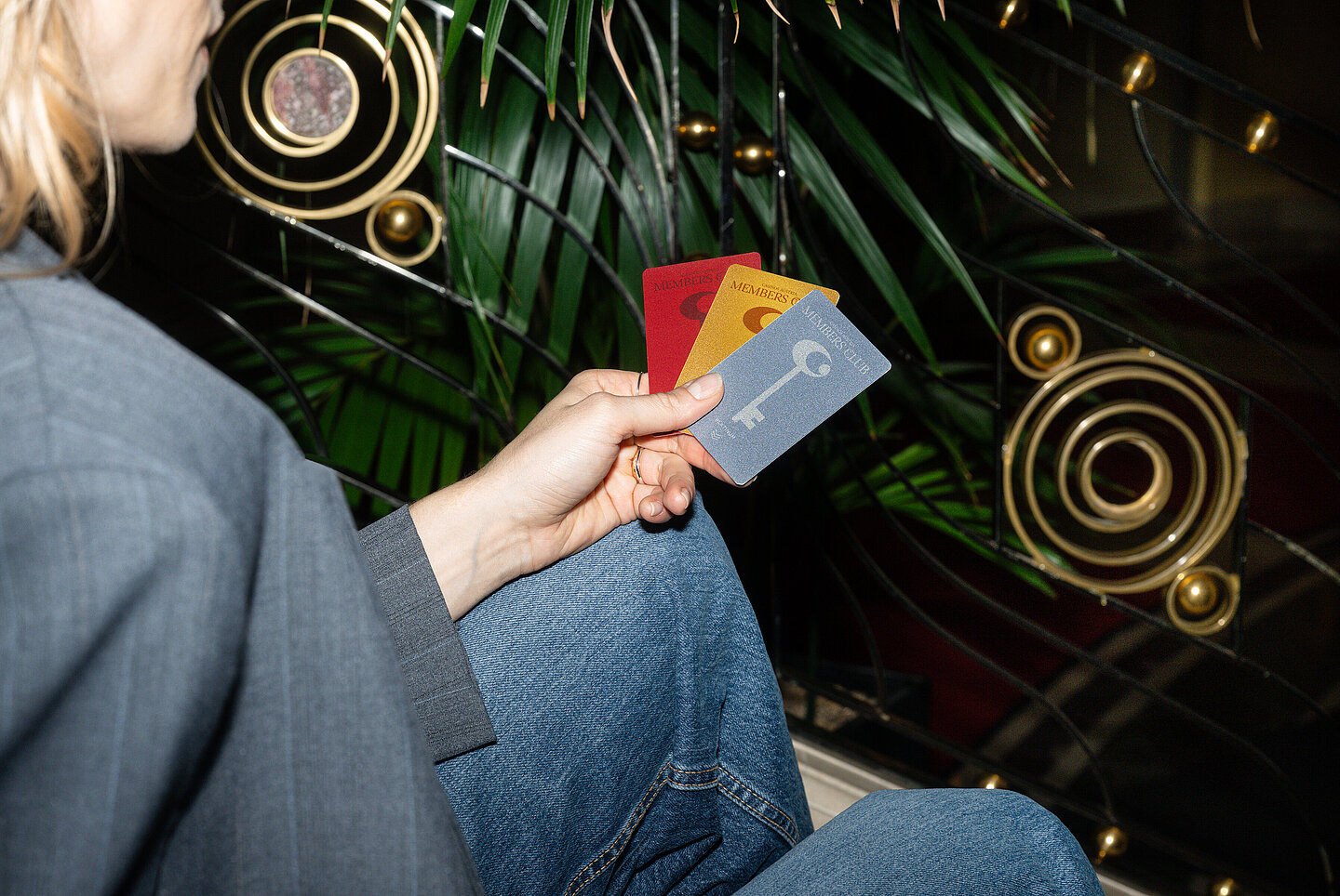 Frau sitzt mit Member Club Cards auf der Stiege