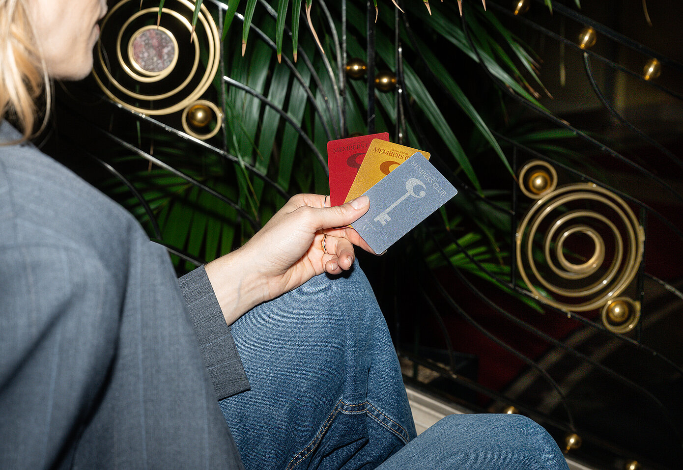 Frau sitzt mit Member Club Cards auf der Stiege