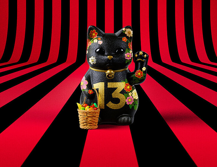 13er Glückskatze mit Blumen und Korb auf rot-schwarz-gestreiftem Hintergrund